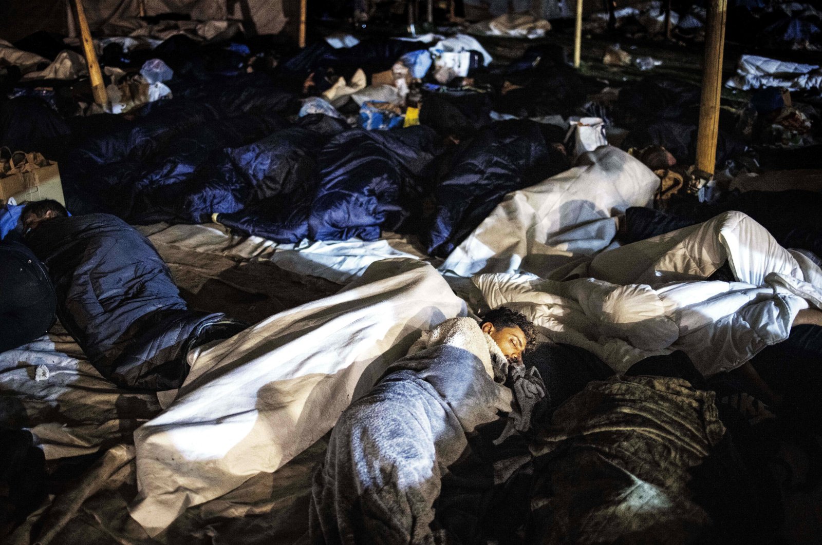 Asylum-seekers sleep on the ground for a third night in a row, outside the registration and application center in Ter Apel, the Netherlands, on Aug. 26, 2022. (AFP Photo)