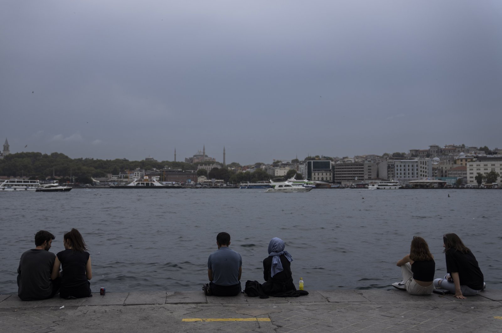 People enjoy their time sitting on the Karakoy beach in Istanbul, Türkiye, Aug. 24, 2022. (AP Photo)
