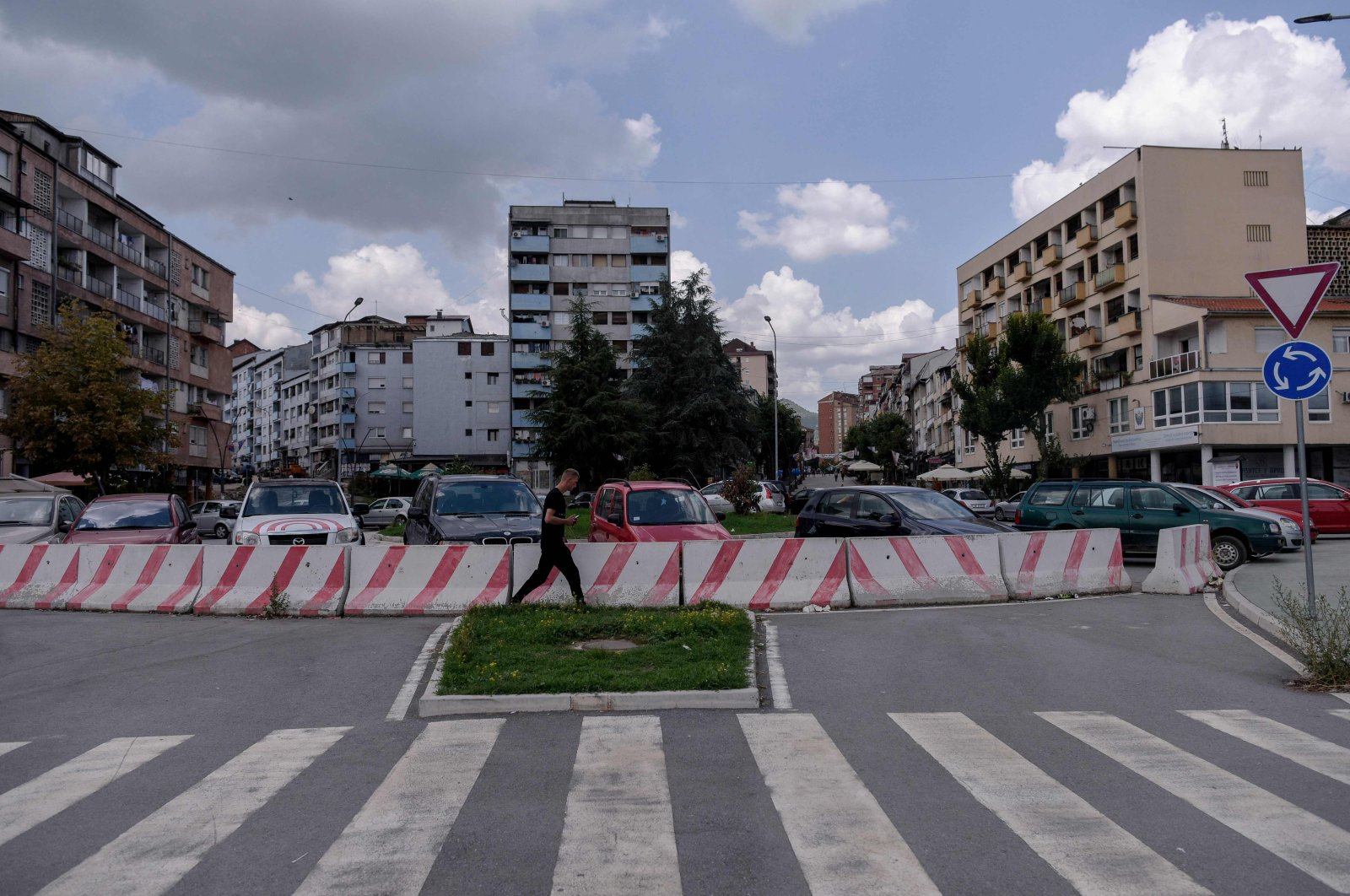 A man walks near the Ibar River bridge in the town of Mitrovica, on August 26, 2022. - Tensions between Serbia and Kosovo soared late last month when Kosovo's government declared that Serb-issued identity documents and vehicle license plates would no longer be valid in Kosovo's territory, just as Kosovo-issued ones are not valid in Serbia. (Photo by Armend NIMANI / AFP)