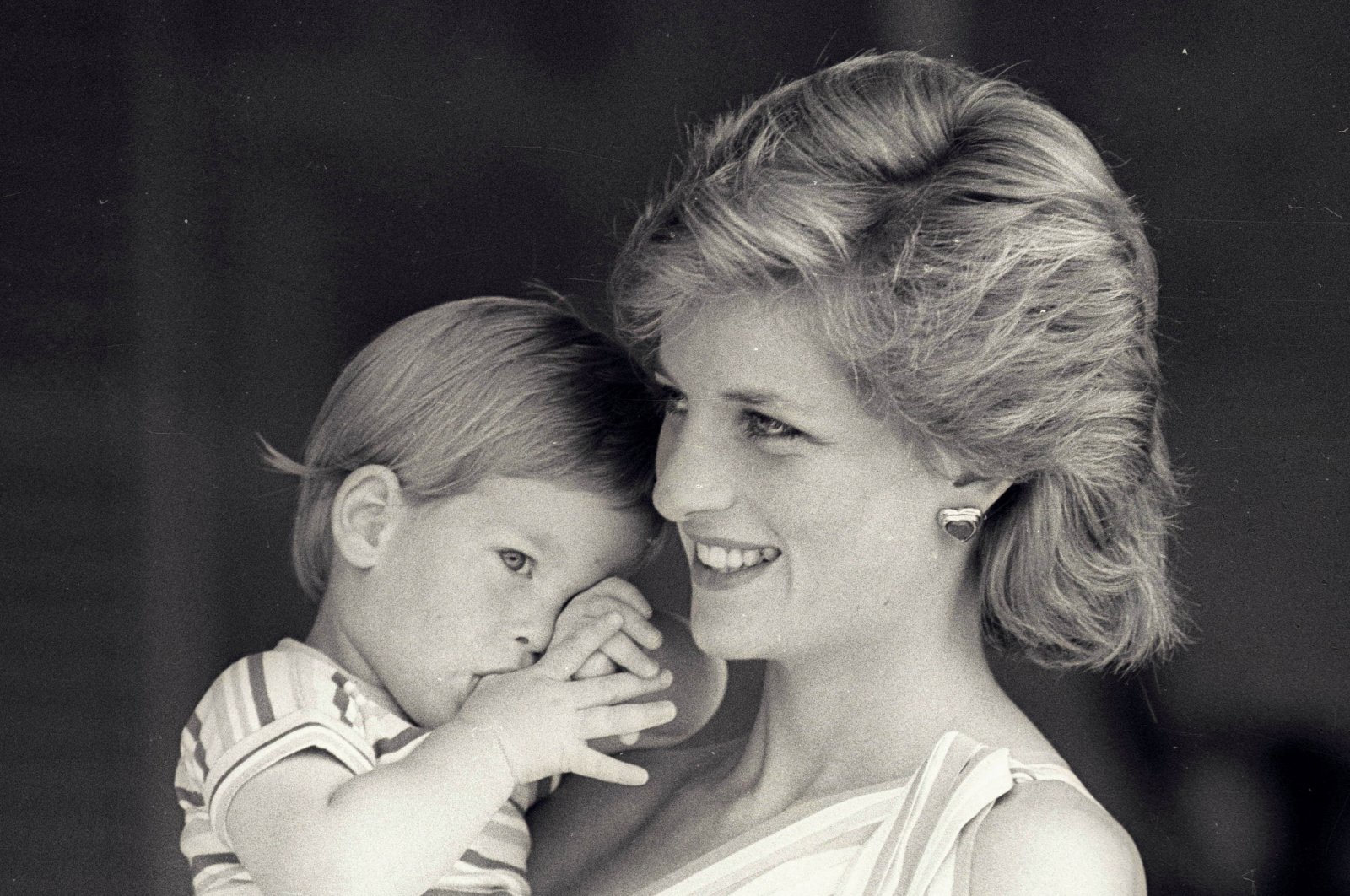 In this file photo, young Prince Harry tries to hide behind his mother, Britain&#039;s Princess Diana, during a morning picture session at Marivent Palace, Spain, Aug. 9, 1988. (Reuters File Photo)