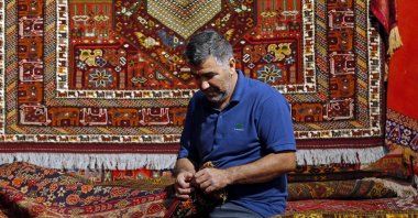 Iranian artisan works during the 29th Handmade Carpet Exhibition in Iran's capital Tehran, Aug. 23, 2022. (AFP)