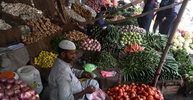 A vendor weighs vegetables for a customer at a local market in Lahore, Pakistan, Aug. 29, 2022. (AFP Photo)