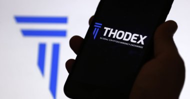 The Thodex cryptocurrency exchange logo is displayed on a mobile phone screen, April 22, 2021. (AA Photo)