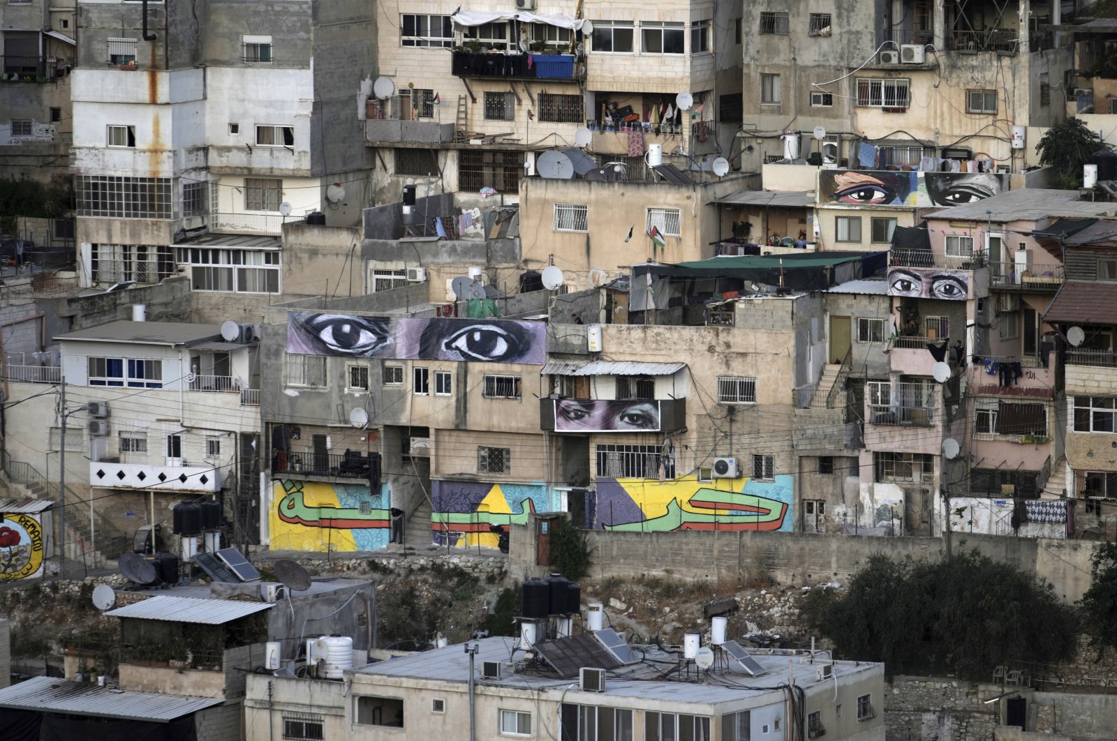 Murals that are part of the public art project &quot;I Witness Silwan,&quot; depicting the eyes of local and international figures, including George Floyd, a black American killed by police, top right, in the Silwan neighborhood of Israeli-occupied East Jerusalem, Palestine, Aug. 26, 2022. (AP Photo)