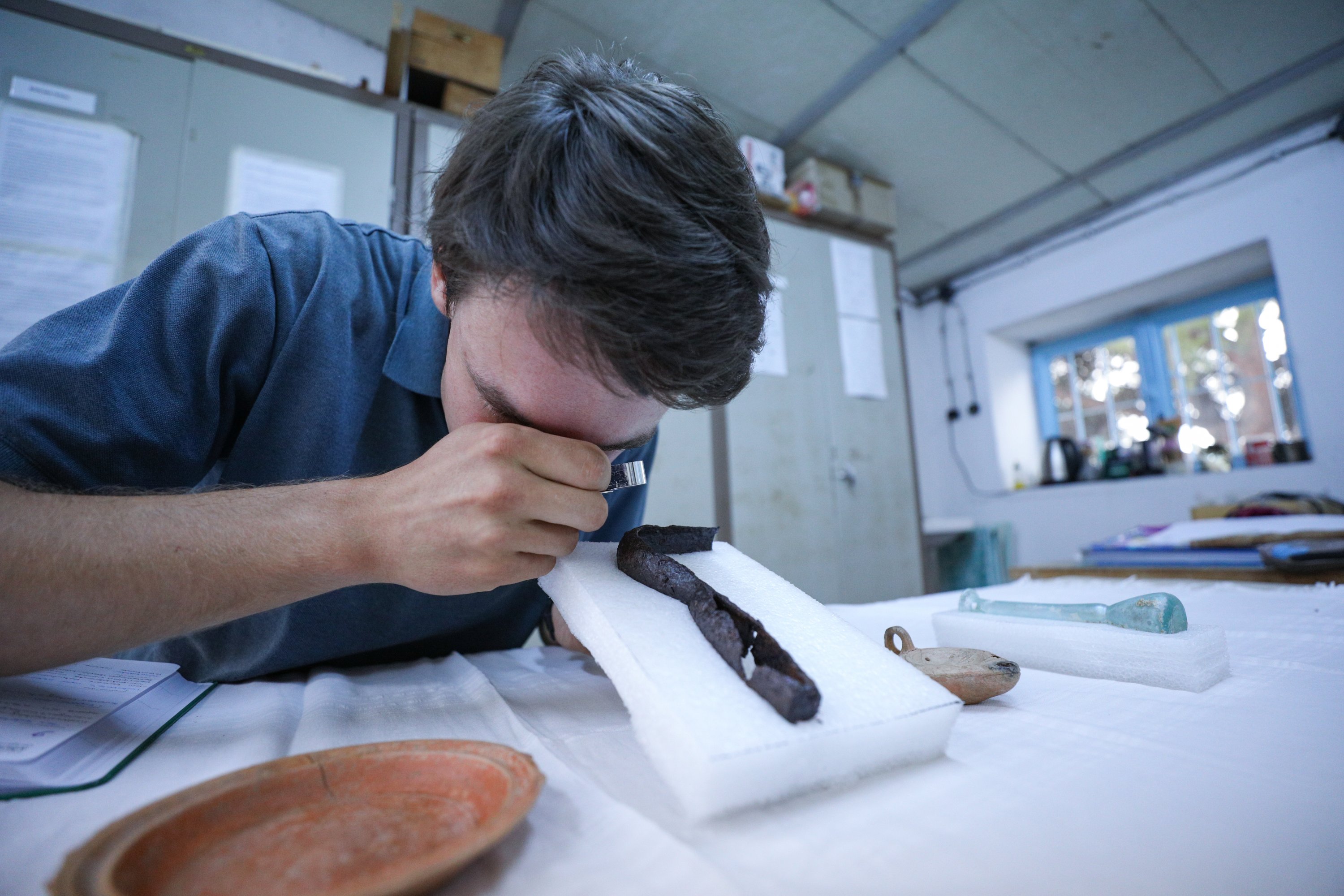 Arkeolog Jakob Krasel dari Universitas Freiburg mengerjakan alat penggores yang disebut strigilis yang ditemukan di makam Markos, yang dikenal sebagai 