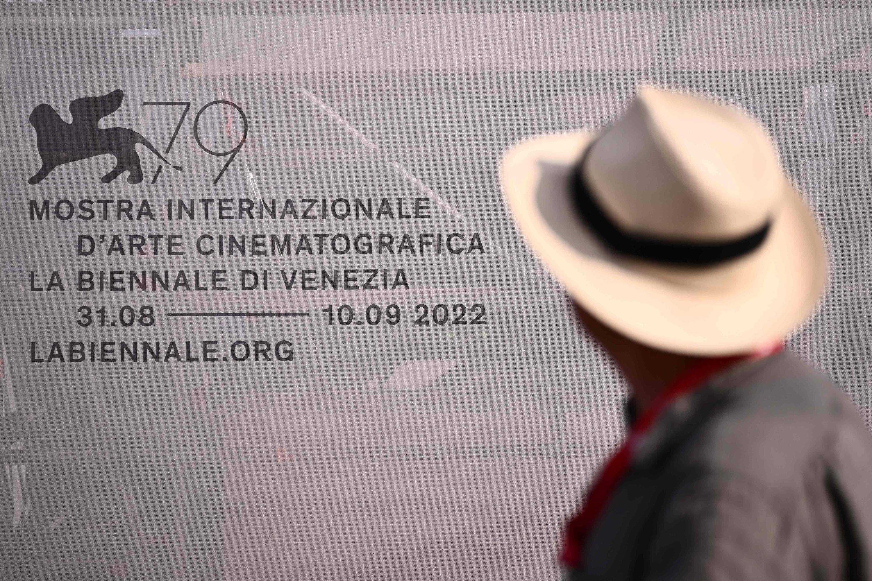 Seorang pengunjung festival melihat logo festival di Lido di Venezia di Venesia, Italia, pada malam pembukaan Festival Film Internasional Venesia ke-79, 30 Agustus 2022. (AFP)