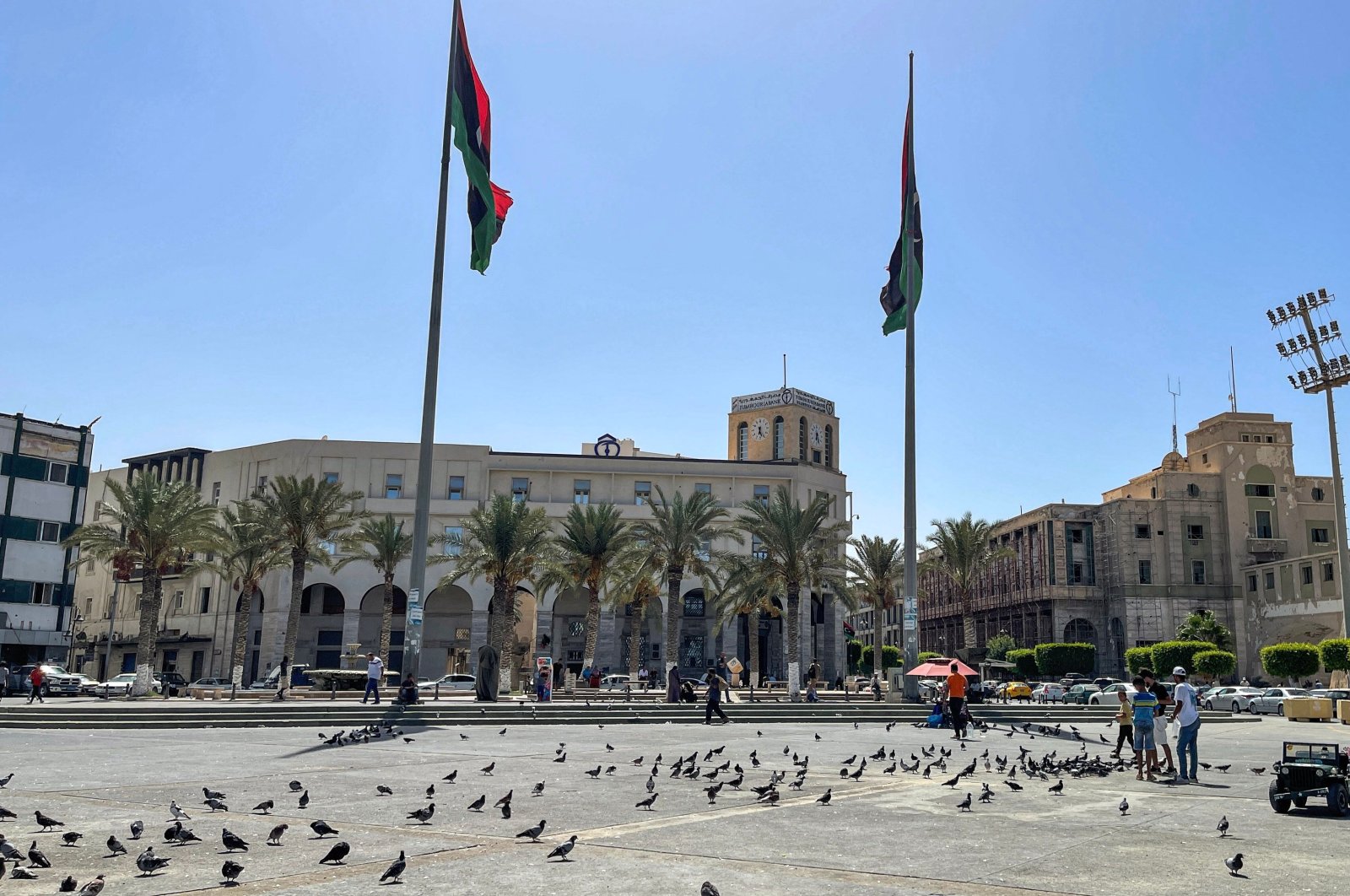 Youths feed pigeons at Martyrs&#039; Square in the center of Libya&#039;s capital Tripoli, Aug. 29, 2022. (AFP Photo)
