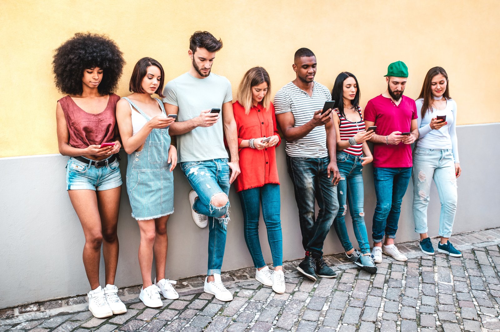 Millennials read the news on their smartphones. (Shutterstock Photo)