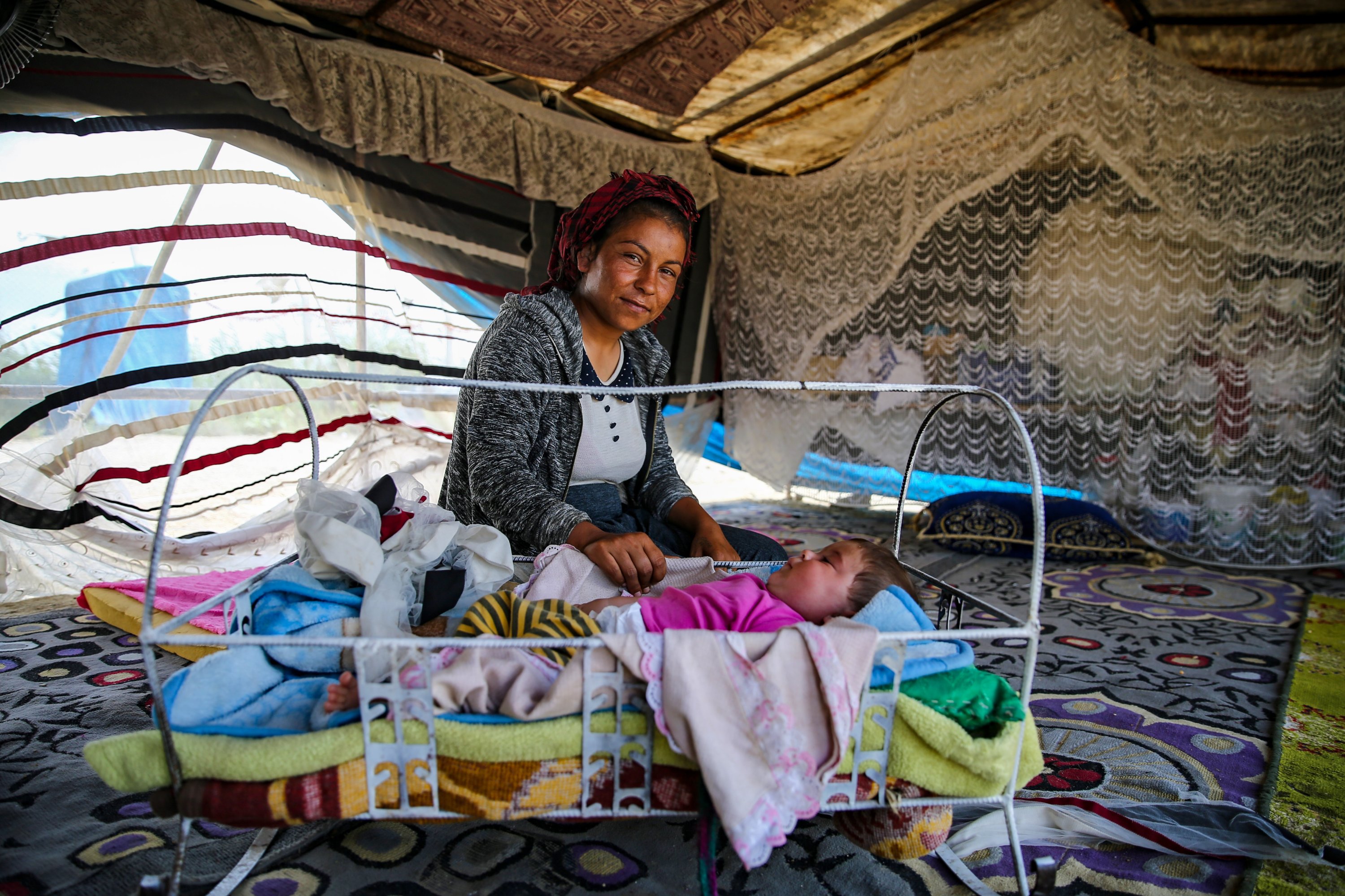 Seorang buruh merawat bayinya di tenda, di Adana, Türkiye selatan, 25 Agustus 2022. (AA PHOTO)