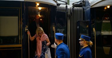 An employee hers a passenger disembark from the Venice Simplon-Orient-Express at Istanbul Station, Türkiye, August 31, 2022. (AFP Photo)