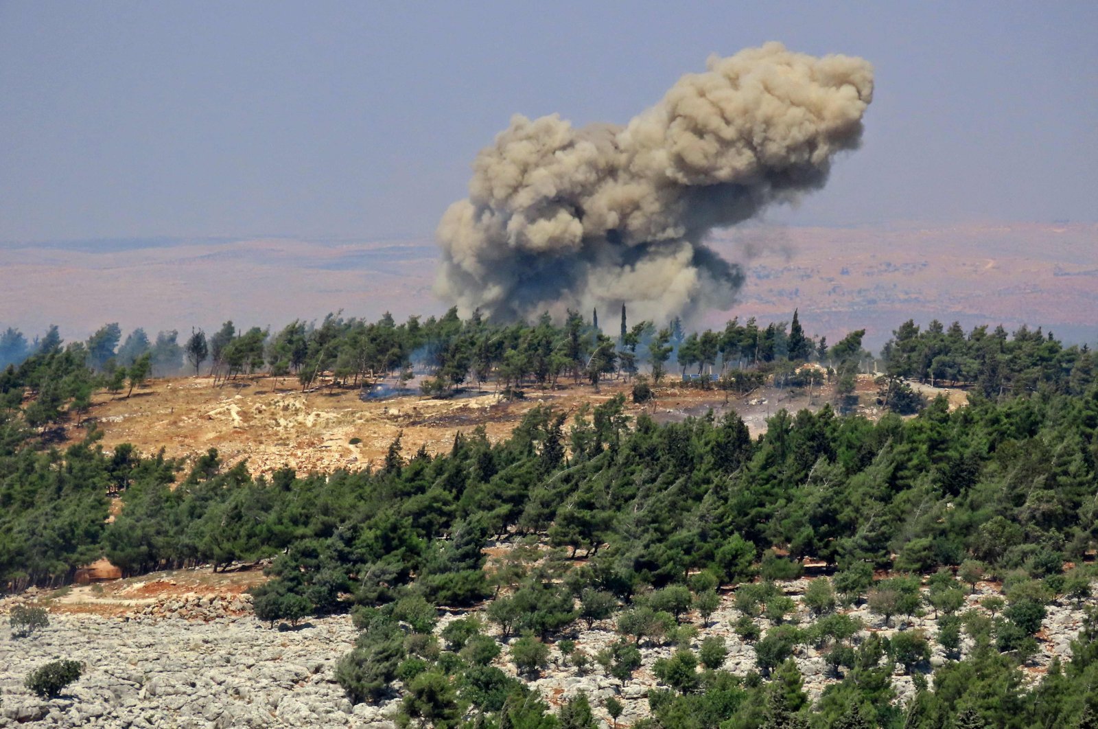 Smoke billows at the site of a reported Russian strike in a forest area west of Syria&#039;s opposition-held northwestern city of Idlib, Aug. 22, 2022. (AFP Photo)
