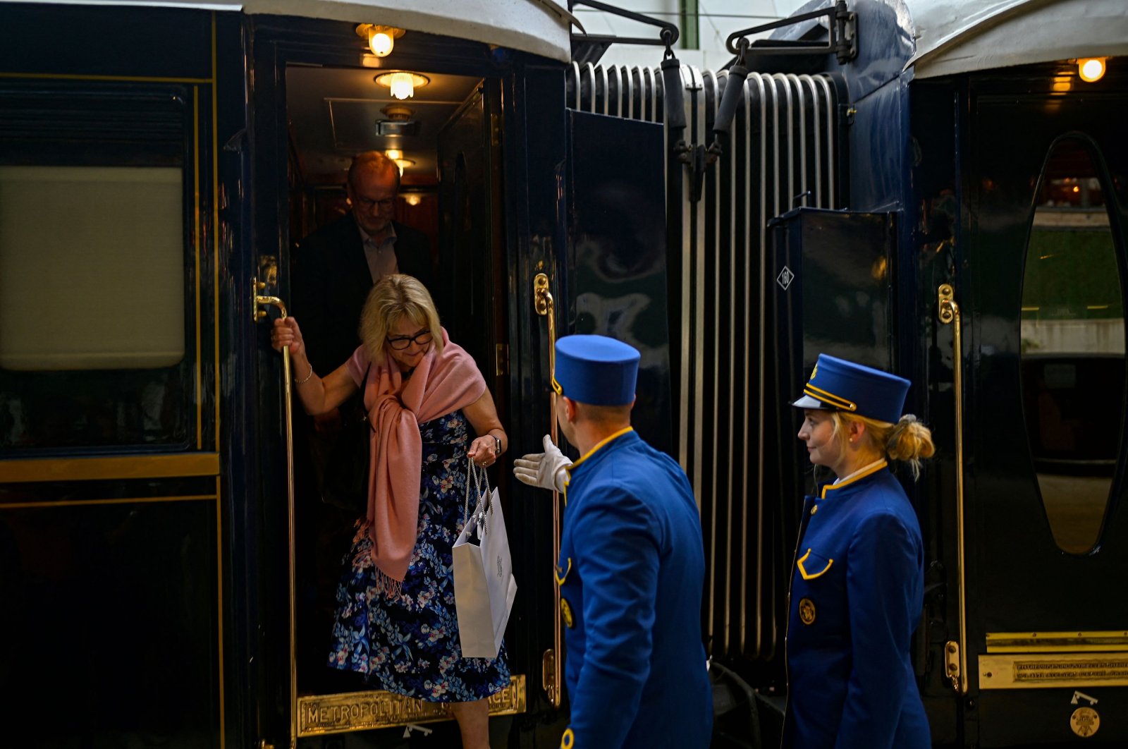 An employee hers a passenger disembark from the Venice Simplon-Orient-Express at Istanbul Station, Türkiye, August 31, 2022. (AFP Photo)