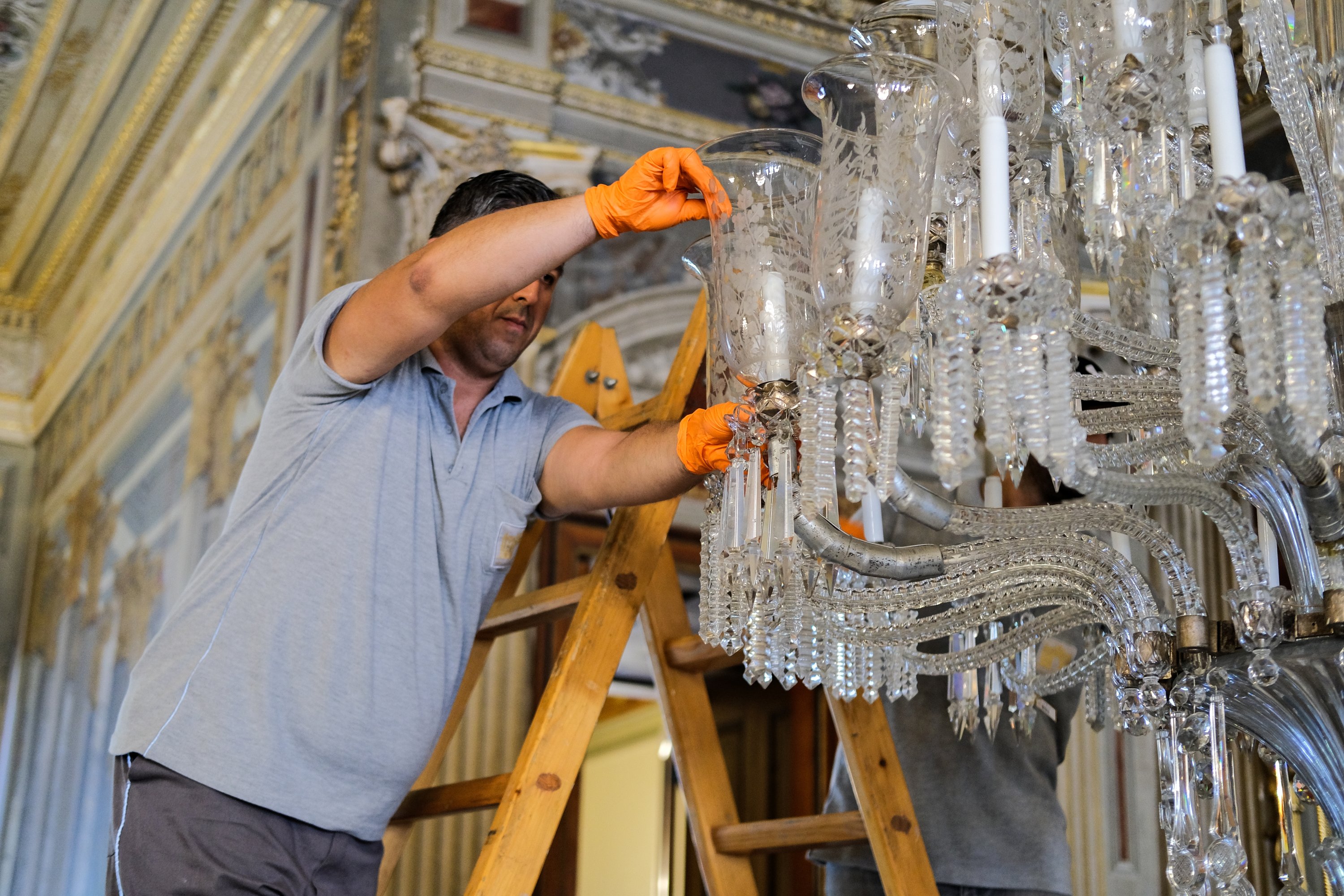 An expert works on a chandelier at Dolmabahçe Palace, Istanbul, Türkiye, Sept. 2, 2022. (AA Photo)