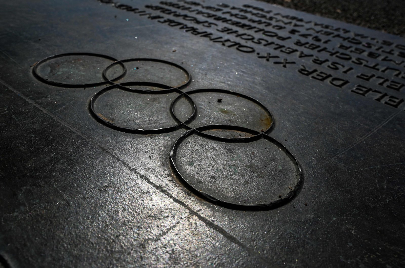 A commemorative plaque with the Olympic Rings in front of the Memorial to the Victims of the 1972 Olympic Attack at the Olympic Park in Munich, Germany, Aug. 17, 2022. (AFP Photo)