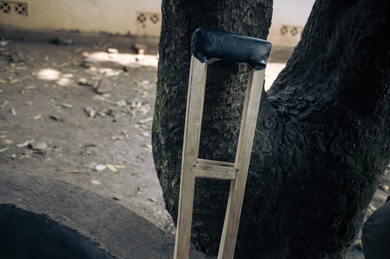A wooden crutch used by a young militiaman with a gunshot wound to the leg is seen against a tree at Rutshuru Hospital in the eastern province of North Kivu, Democratic Republic of Congo, July 23, 2022. (AFP Photo)