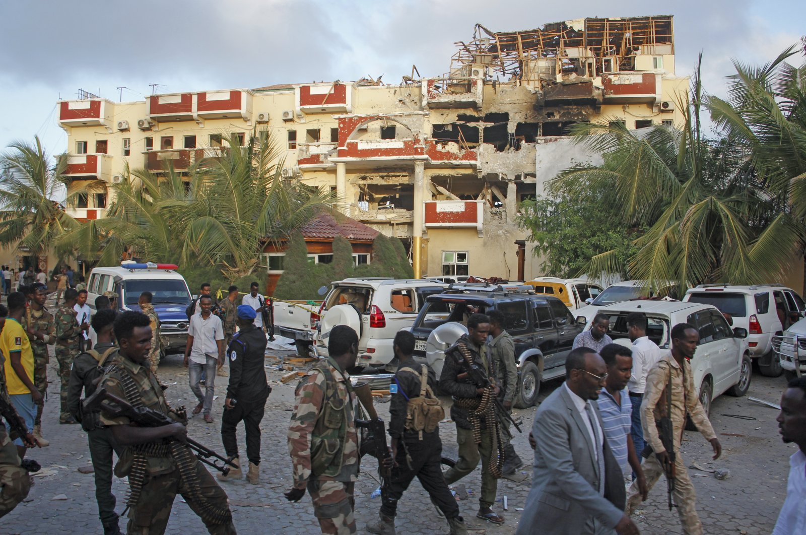 Security forces and others walk in front of the damaged Hayat Hotel in the capital Mogadishu, Somalia, Aug. 21, 2022. (AP Photo)