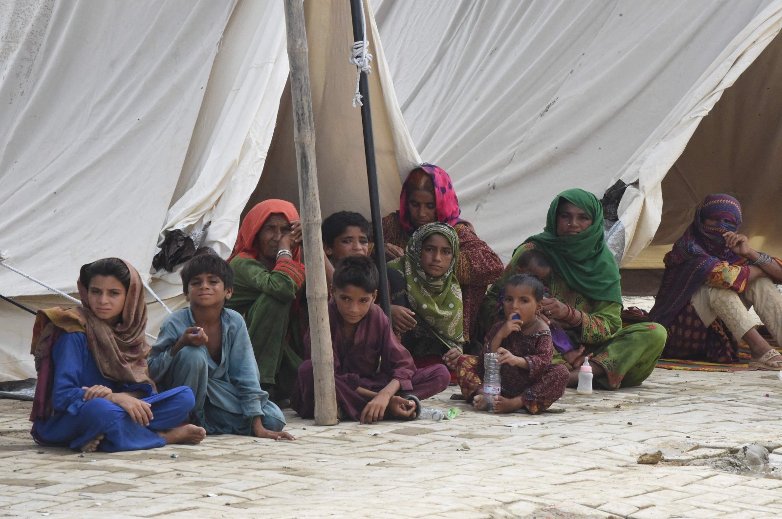 Flood-affected people sit in a tent at a makeshift camp after heavy monsoon rains in Jaffarabad district, Balochistan province, Pakistan, Sept. 3, 2022. (AFP Photo)
