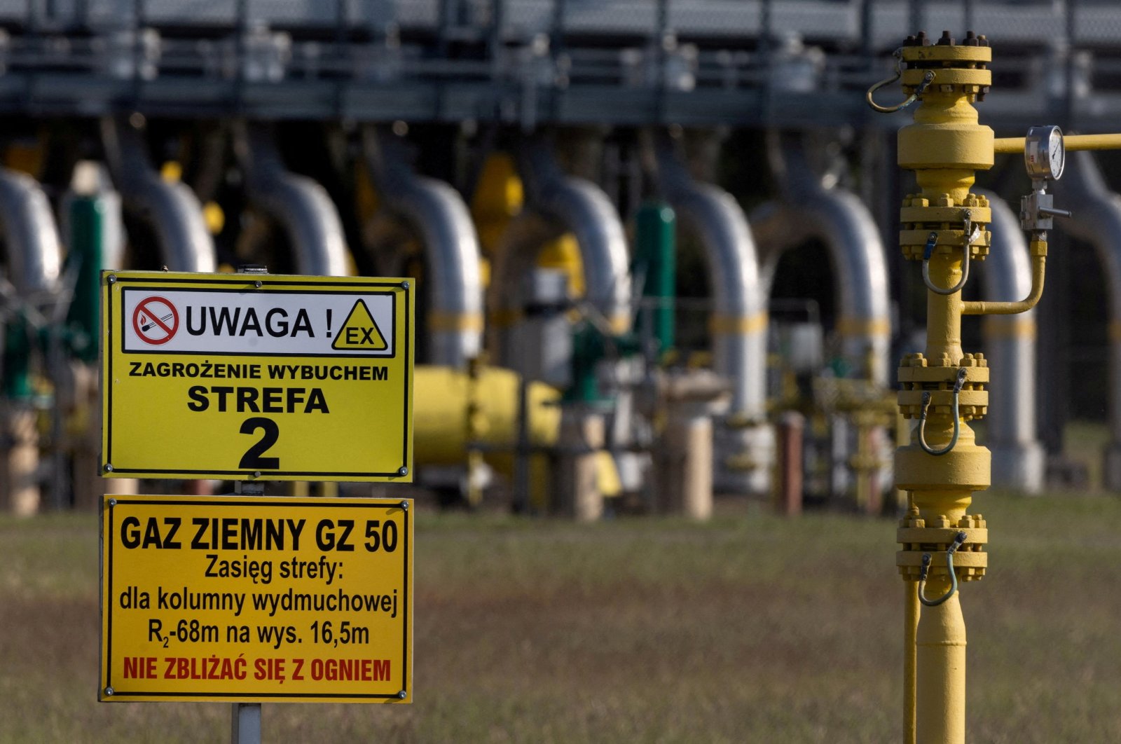Warning signs are pictured in front of the gas compressor station, part of the Polish section of the Yamal pipeline that links Russia with Western Europe owned by a joint venture of Gazprom and PGNiG but it is operated by Poland&#039;s state-owned gas transmission company Gaz-System, in Gabinek near Wloclawek, Poland, May 23, 2022. (Reuters Photo)