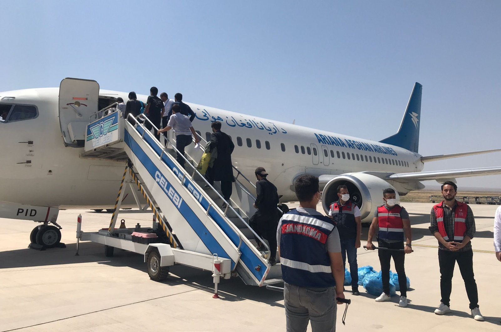 A group of illegal migrants boards a plane before deportation from Iğdır, Türkiye, Aug. 15, 2022. (IHA Photo)