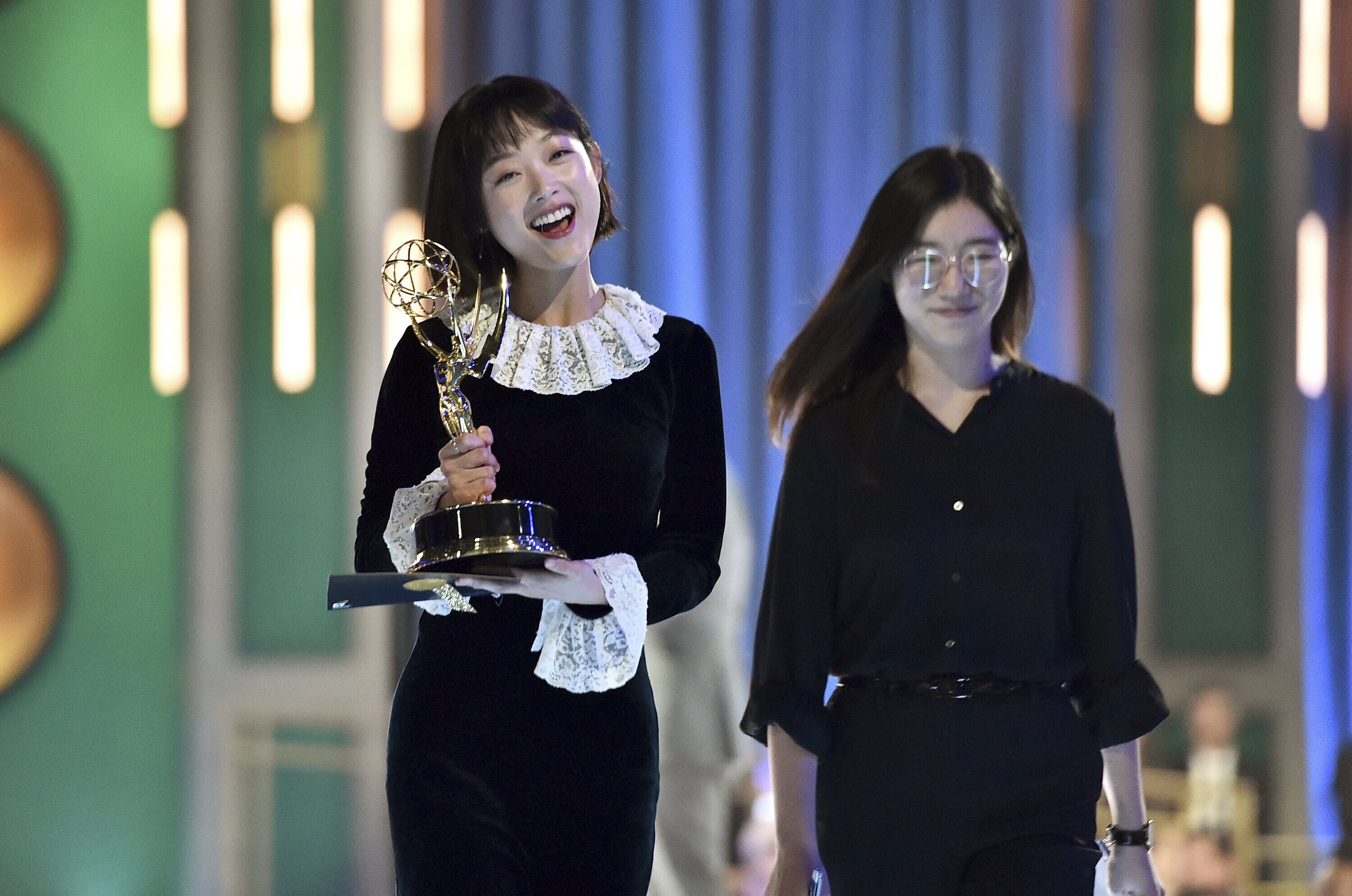 Lee You-mi (L) and a translator walking backstage after she wins the Emmy for outstanding guest actress in a drama series for the "Gganbu" episode of "Squid Game" on the 2nd night of the Television Academy's 2022 Creative Arts Emmy Awards, Los Angeles, U.S., Sept. 4, 2022. (AP Photo)