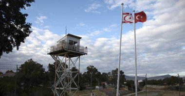 A U.N. guard post is seen on the buffer zone as a Turkish and a Turkish Cypriot flag wave on the Turkish part of the divided capital Nicosia (Lefkoşa), TRNC, Jan. 12, 2017. (REUTERS)
