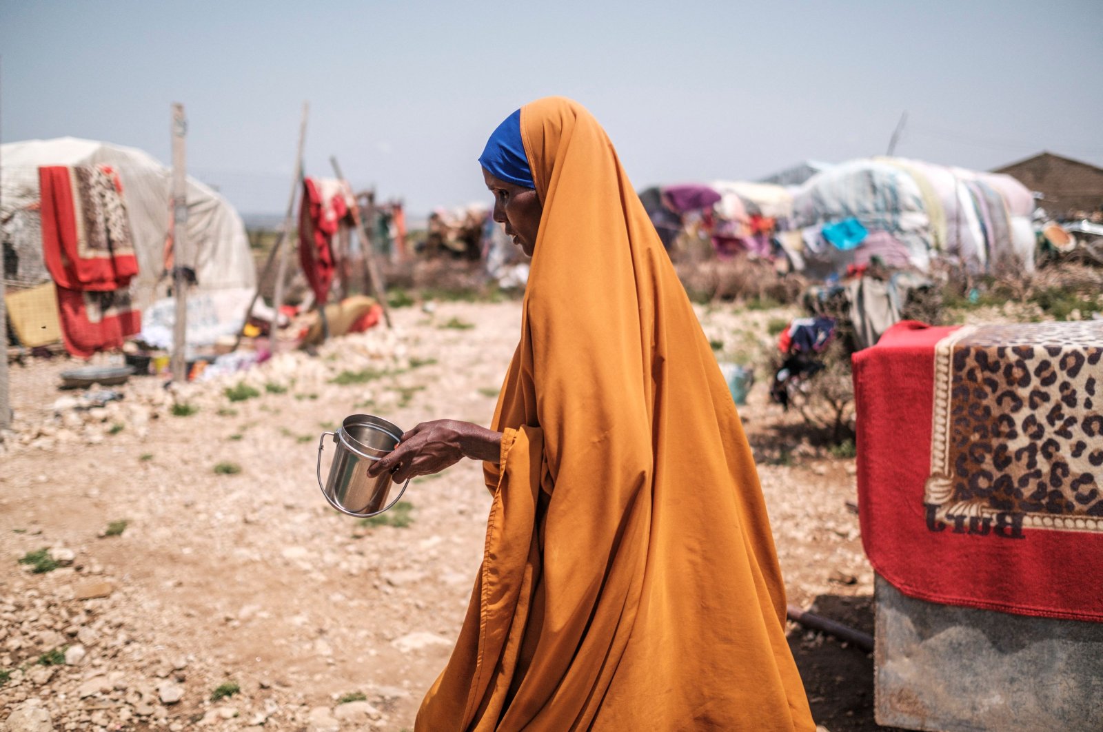 Yurub Abdi Jama, a 35-year-old mother of eight children, walks while holding a cup in an informal settlement of internally displaced people in the outskirts of the city of Hargeisa, Somaliland, Somalia, Sept. 16, 2021. (AFP File Photo)