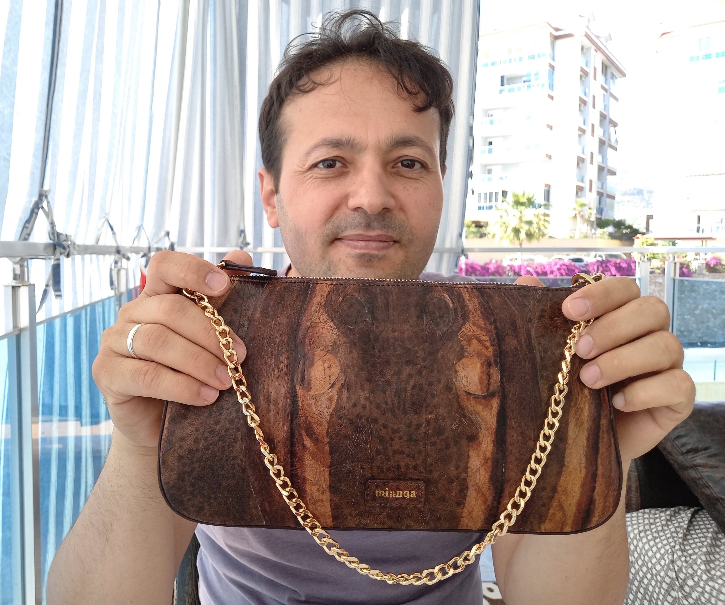 Mehmet zata memegang tas yang terbuat dari kulit ikan buntal ke arah kamera, di Antalya, Türkiye, 24 Agustus 2022. (Foto dpa)