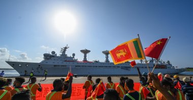 Workers wave the national flags of China and Sri Lanka upon the arrival of China's research and survey vessel, the Yuan Wang 5 at Hambantota port, Sri Lanka, Aug. 16, 2022. (AFP Photo)