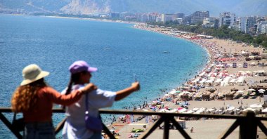 Visitors take a photo with the famed Konyaaltı Beach in the background in Antalya, southern Türkiye, Aug. 27, 2022. (IHA Photo)