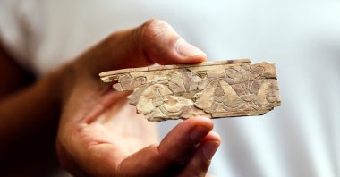A worker holds an ivory plaque unearthed in excavations near the walls of Jerusalem's Old City, East Jerusalem, occupied Palestine, Sept. 5, 2022. (Reuters Photo)