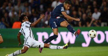 PSG's Kylian Mbappe (R) shoots past Juventus' Juan Cuadrado in a Champions League match, Paris, France, Sept. 6, 2022. (AFP Photo)