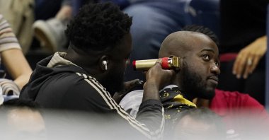 A fan gets a haircut in the stands during a U.S. Open quarterfinal, New York, U.S., Sept. 6, 2022. (AP Photo)