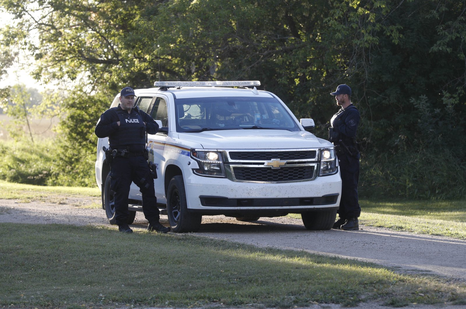 Royal Canadian Mounted Police officers stand next to a police vehicle outside the house where one of the stabbing victims was found in Weldon, Saskatchewan, Canada, Sept. 6, 2022. (AFP Photo)