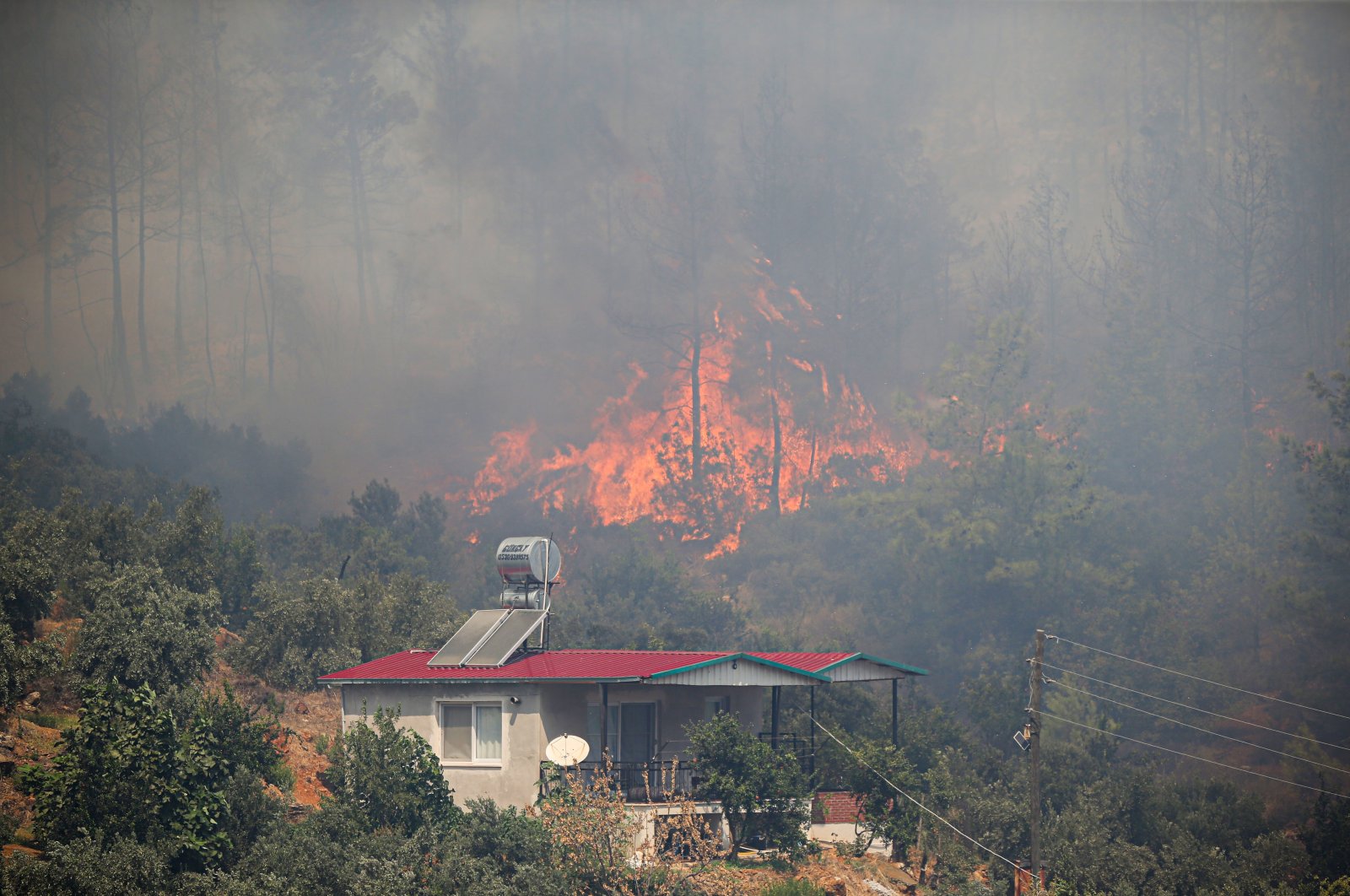 Flames approach a house, in Mersin, southern Türkiye, Sept. 7, 2022. (AA PHOTO) 