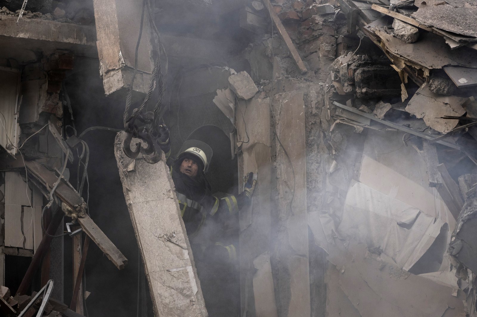 A firefighter works to extinguish a fire as he looks for potential victims after a Russian attack which heavily damaged a residential building in Sloviansk, Ukraine, Sept. 7, 2022. (AP Photo)