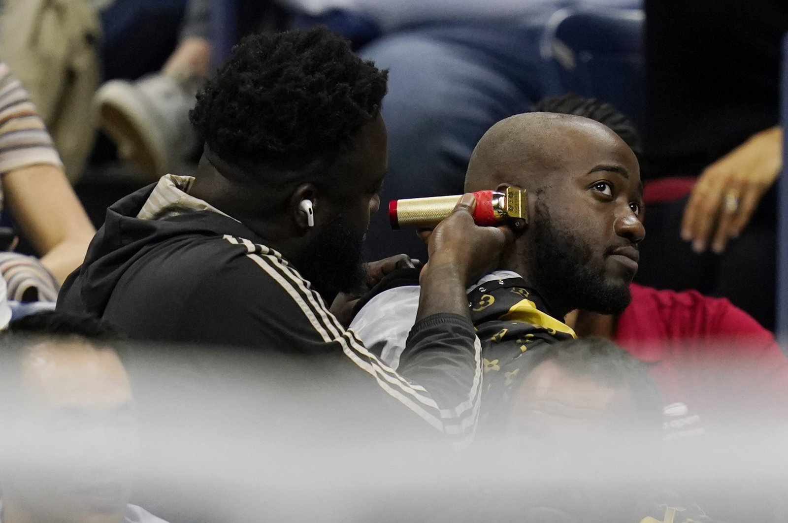 A fan gets a haircut in the stands during a U.S. Open quarterfinal, New York, U.S., Sept. 6, 2022. (AP Photo)