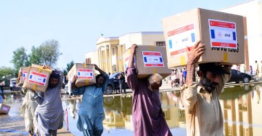 People carry aid delivered by AFAD in Mirpur Khas, Pakistan, Sept. 8, 2022. (AA PHOTO) 