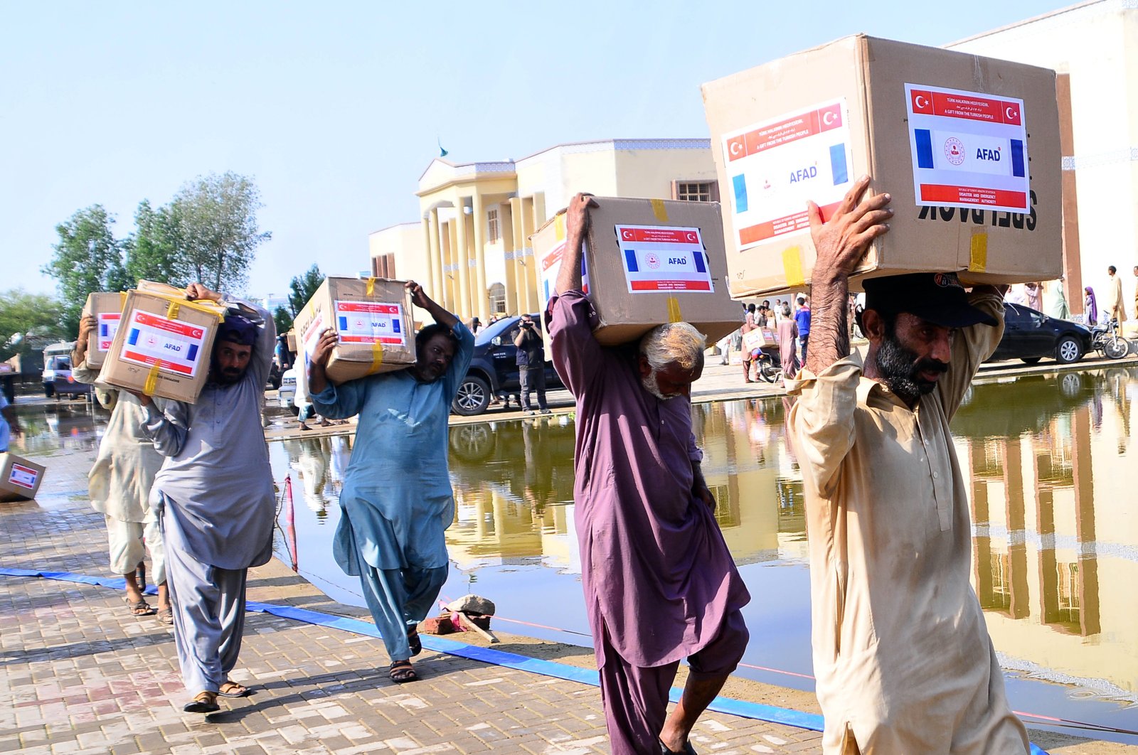 People carry aid delivered by AFAD in Mirpur Khas, Pakistan, Sept. 8, 2022. (AA PHOTO) 