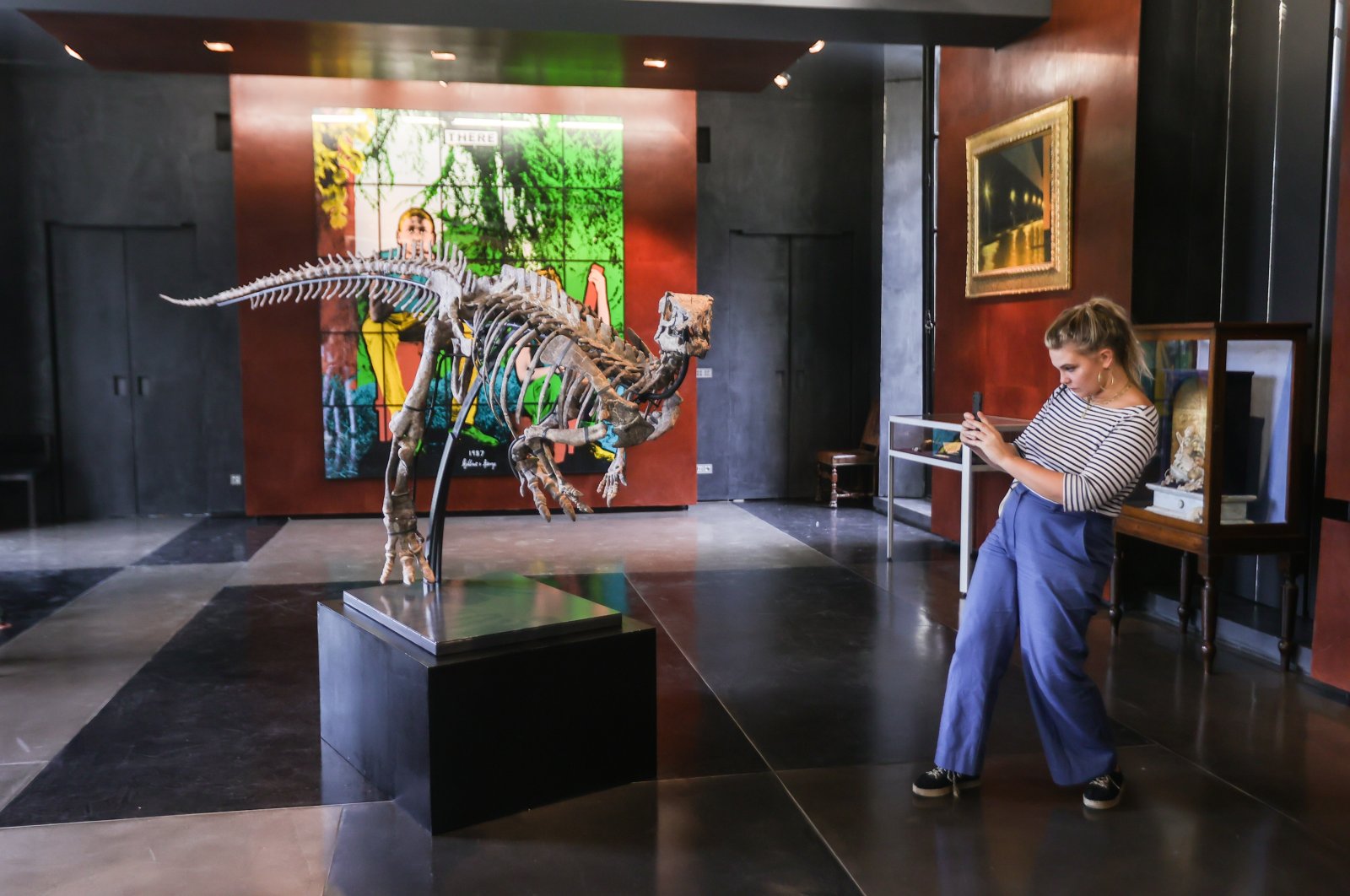 A journalist takes a picture of the full skeleton of an Iguanodon dinosaur on display at the Alexandre Giquello auction house during a press presentation in Paris, France, Sept. 7, 2022. (EPA Photo)