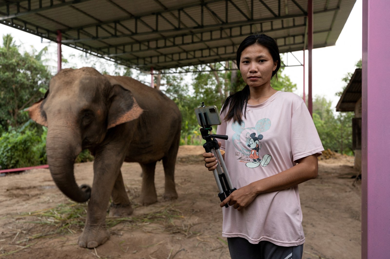 Elephant owner Siriporn Sapmak, 23, poses while holding her gear used for social media live-streaming outside her house, at Ban Ta Klang village in Surin, Thailand, April 6, 2022. (Reuters Photo)