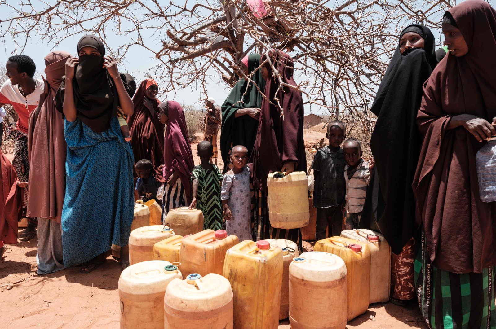 People wait to fill their water tanks as they receive a twice-a-week water delivery by Save the Children in Kubdisha, Kenya, Sept. 1, 2022. (AFP Photo)