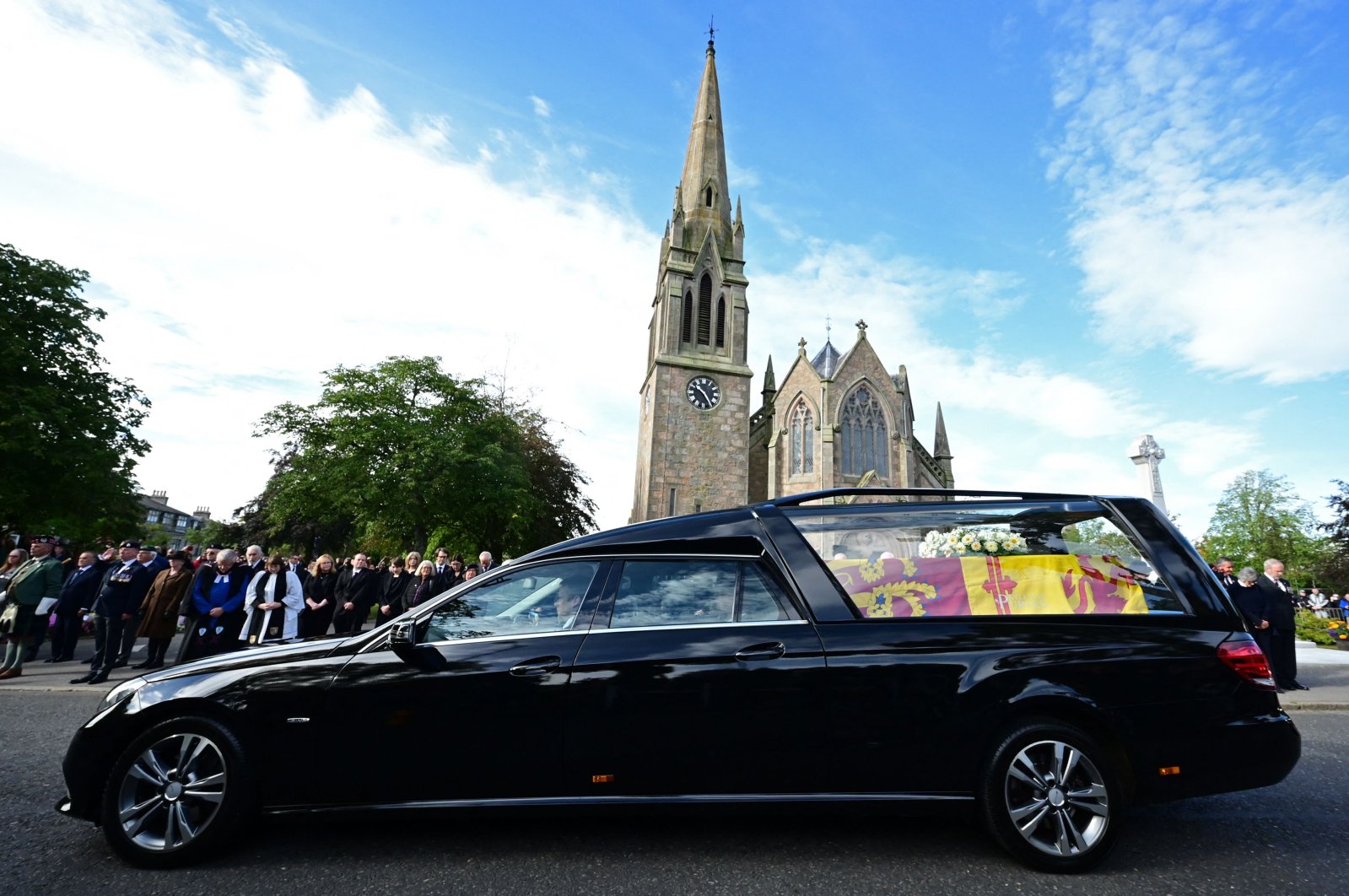 Members of the Public pay their respects as the hearse carrying the coffin of Queen Elizabeth II is driven through Ballater, Scotland, Sept. 11, 2022. (AFP Photo)