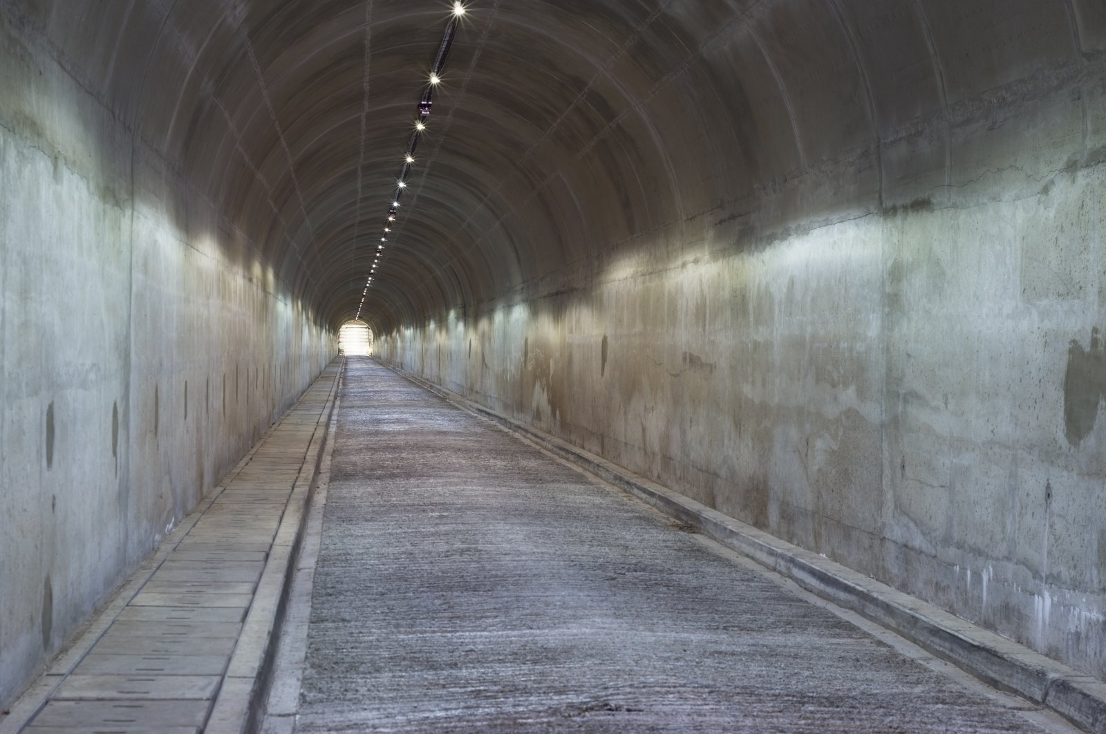 A long concrete tunnel leads down underneath a dam wall in South Africa (shutterstock)