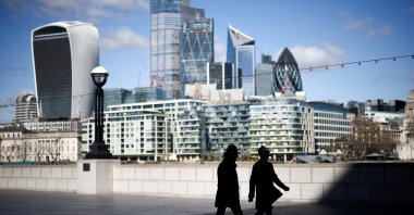 The City of London financial district can be seen as people walk along the south side of the River Thames, London, Britain, March 19, 2021. (Reuters Photo)