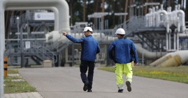 Workers walk past facilities to receive and distribute natural gas on the grounds of gas transport and pipeline network operator Gascade in Lubmin, northeastern Germany, close to the border with Poland, Aug. 30, 2022. (AFP Photo)