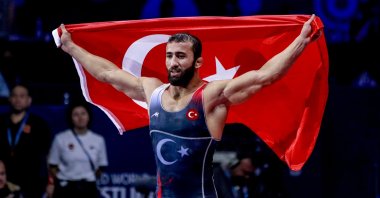 Burhan Akbudak of Türkiye celebrates by waving a national flag after winning gold in the men’s Greco-Roman 82 kg category at the World Wrestling Championships, Belgrade, Serbia, Sept. 12, 2022. (AA Photo)