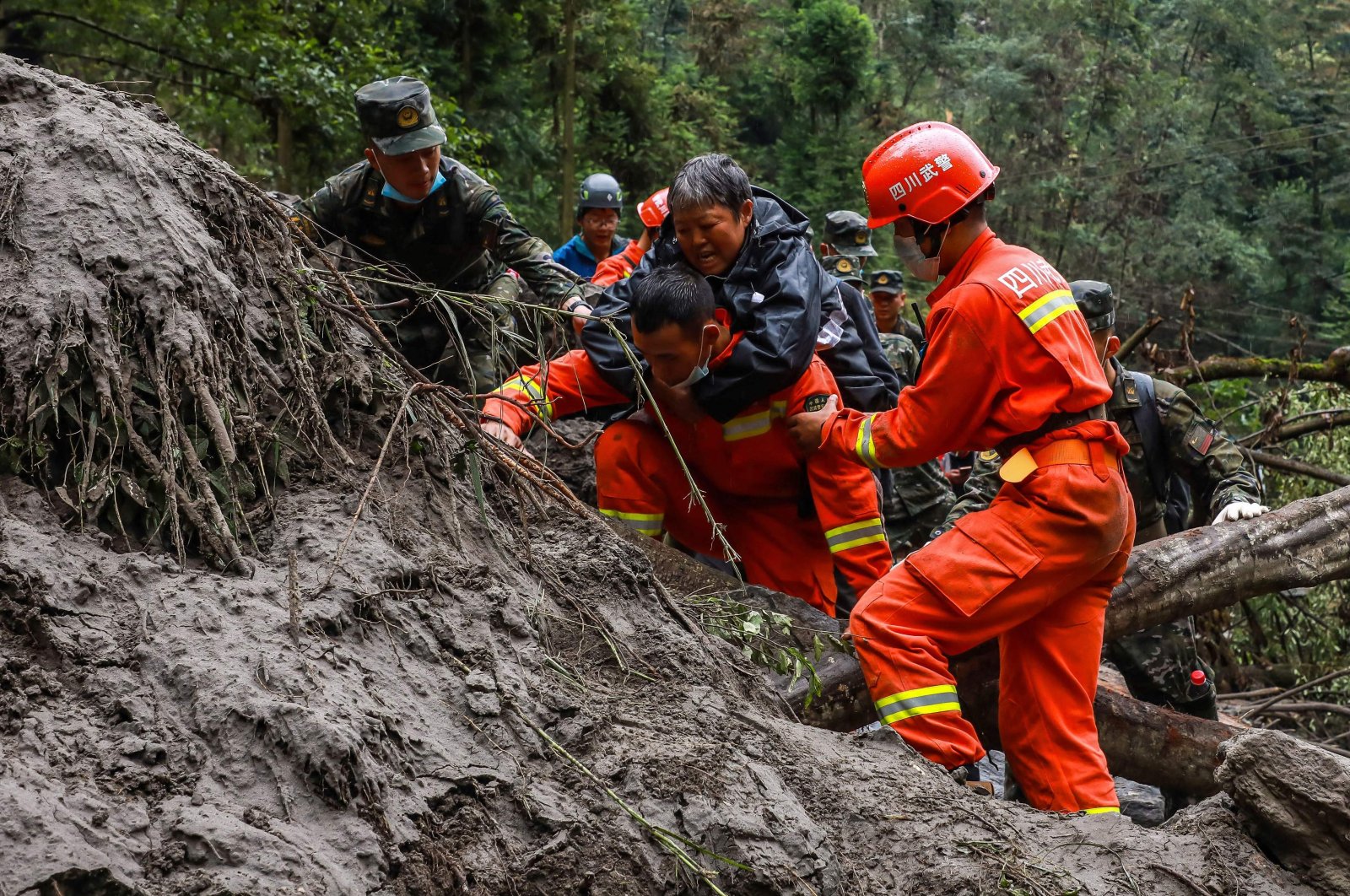 Paramilitary police officers and rescuers evacuate residents following a 6.6 magnitude earthquake in Shimian county, Yaan city, Sichuan province, China, Sept. 8, 2022. (AFP Photo)