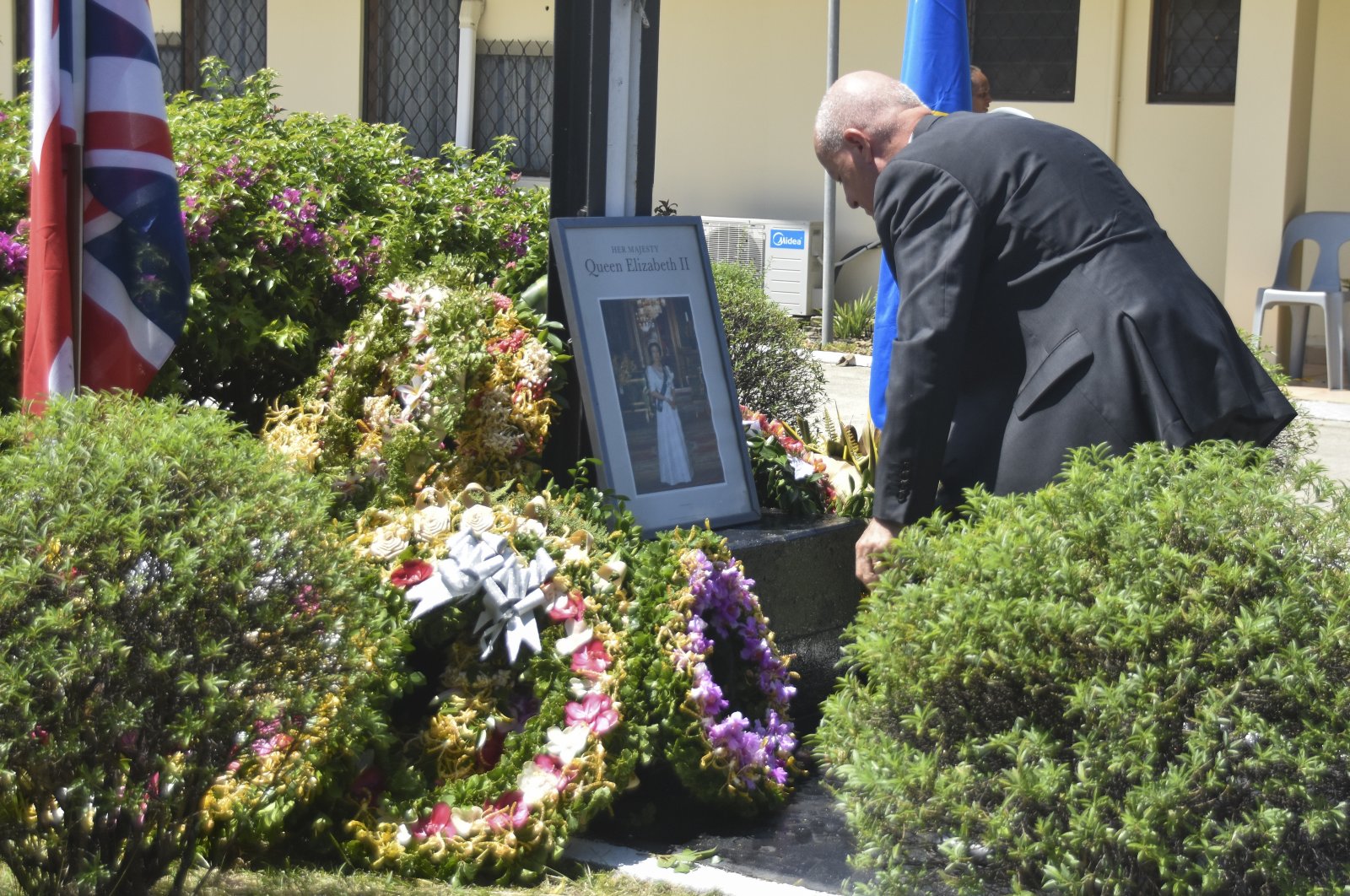 New Zealand High Commissioner to the Solomon Islands, Jonathon Schwass lays a wreath at Government House in Honiara, Solomon Island, during a ceremony to mark the passing of Queen Elizabeth II, Sept. 12, 2022. (AP Photo/Charley Piringi)