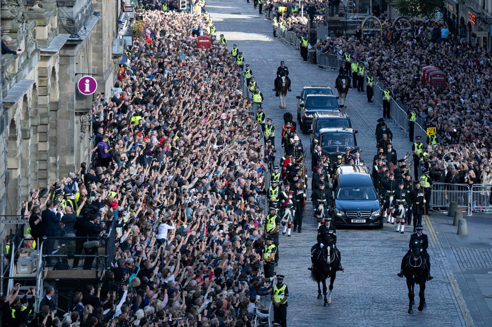 Members of the public watch the procession of the late Queen Elizabeth II&#039;s coffin, from the Palace of Holyroodhouse to St. Giles Cathedral in Edinburgh, on the Royal Mile, where Queen Elizabeth II will lie at rest, Sept. 12, 2022. (AFP Photo)
