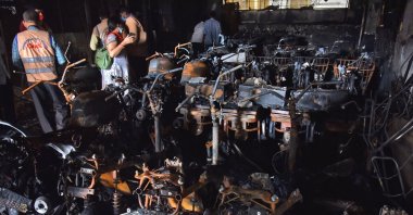 Police officials stand amid damaged scooters after a fire broke out at an electric scooter showroom in the southern city of Secunderabad, India, Sept. 13, 2022. (Reuters Photo)